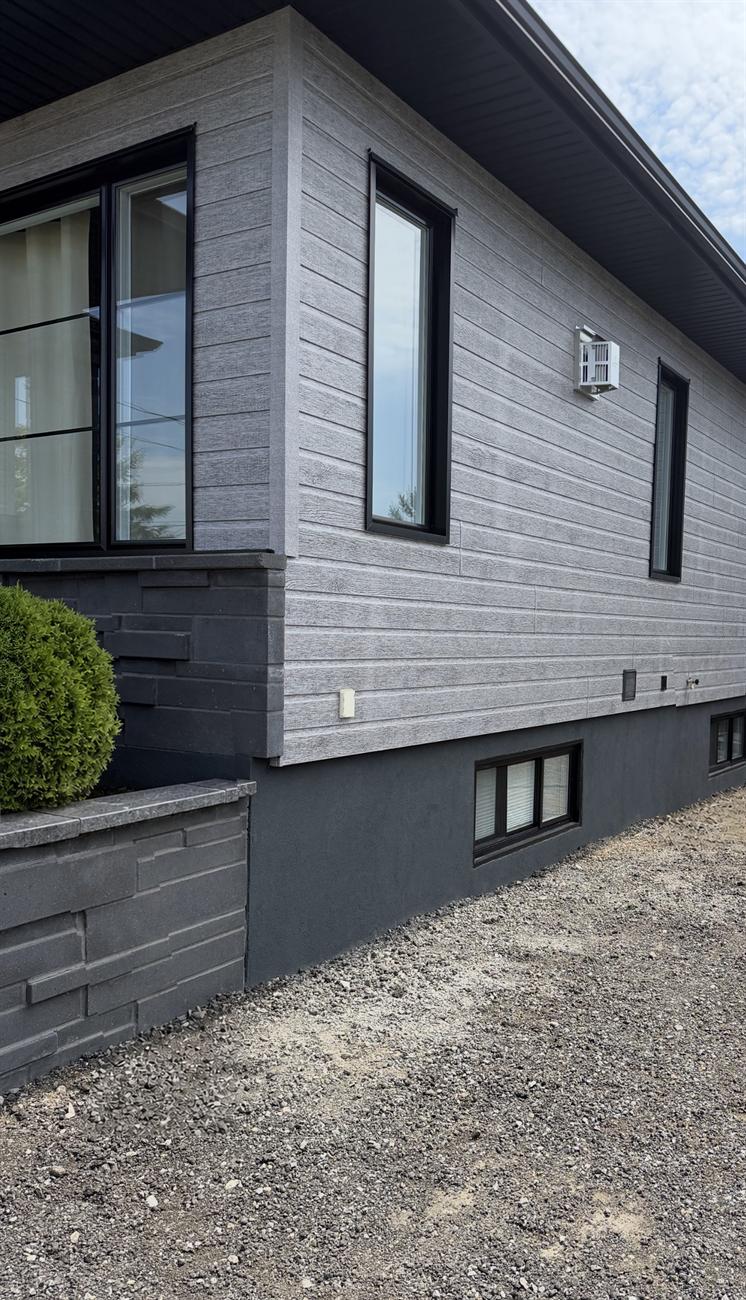 Solage recouvert d'un crépi acrylique gris foncé, fini uniforme